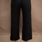 a woman wears a black wide leg Irish linen pants or trousers by Irish brand Madigan