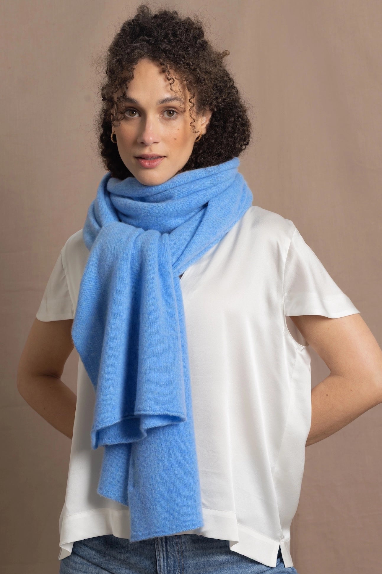a woman wears a cerulean blue cashmere wrap scarf 