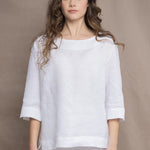 a woman wears a long sleeve pure Irish Linen top in white by Irish brand Madigan 