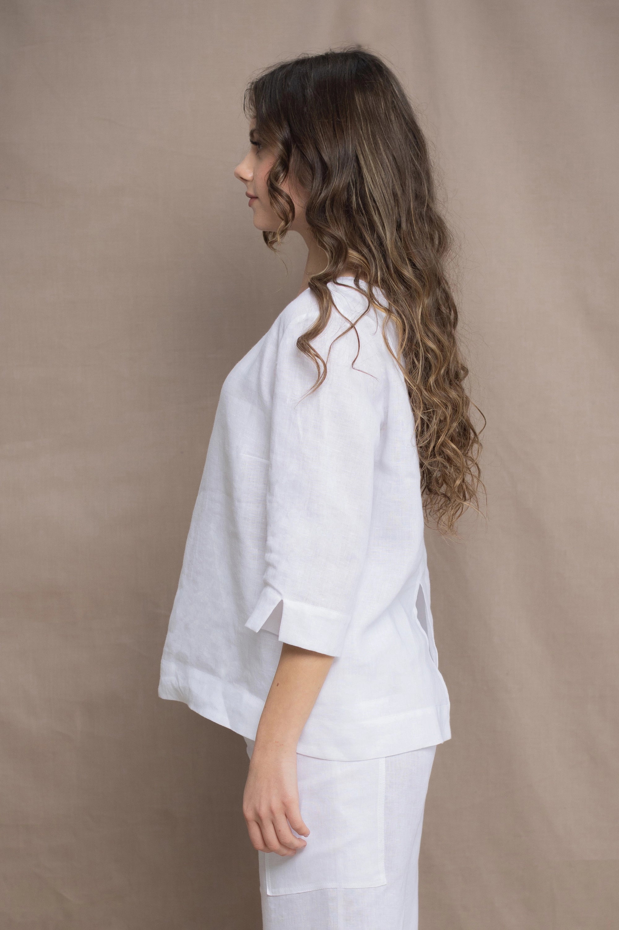 a woman wears a long sleeve pure Irish Linen top in white by Irish brand Madigan 
