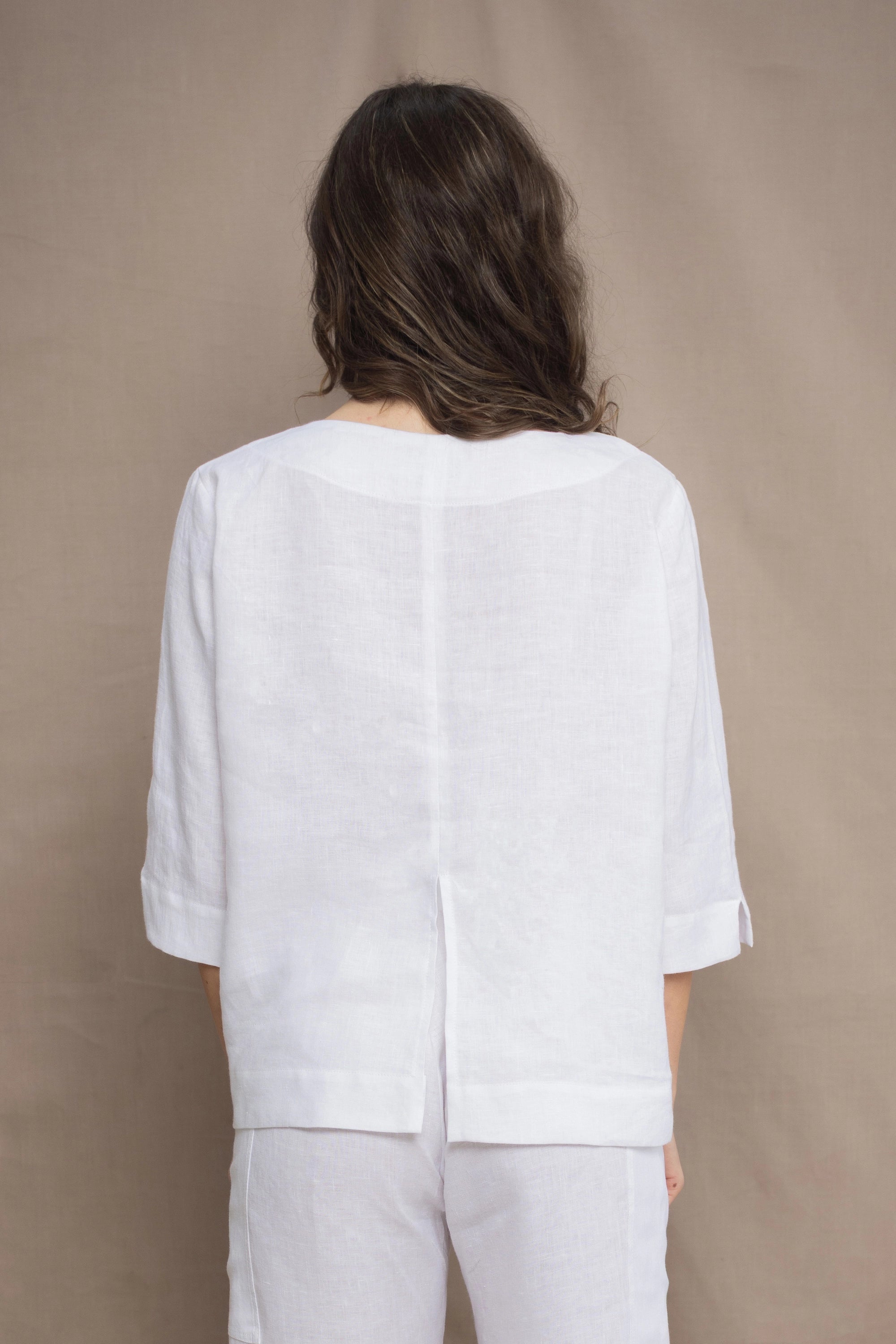 a woman wears a long sleeve pure Irish Linen top in white by Irish brand Madigan 