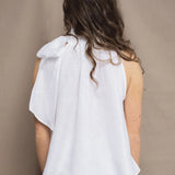 a woman wears an Irish linen halter top with bow detailing on the shoulder in white with matching white linen trousers 