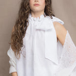 a woman wears an Irish linen halter top with bow detailing on the shoulder in white