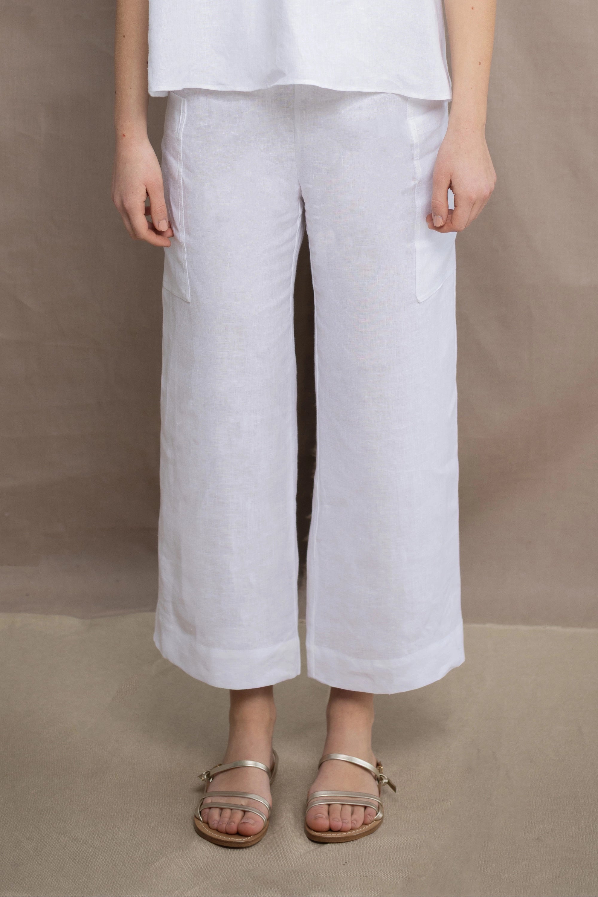 a woman wears a pair of pure Irish linen Cropped trousers in white by Irish brand