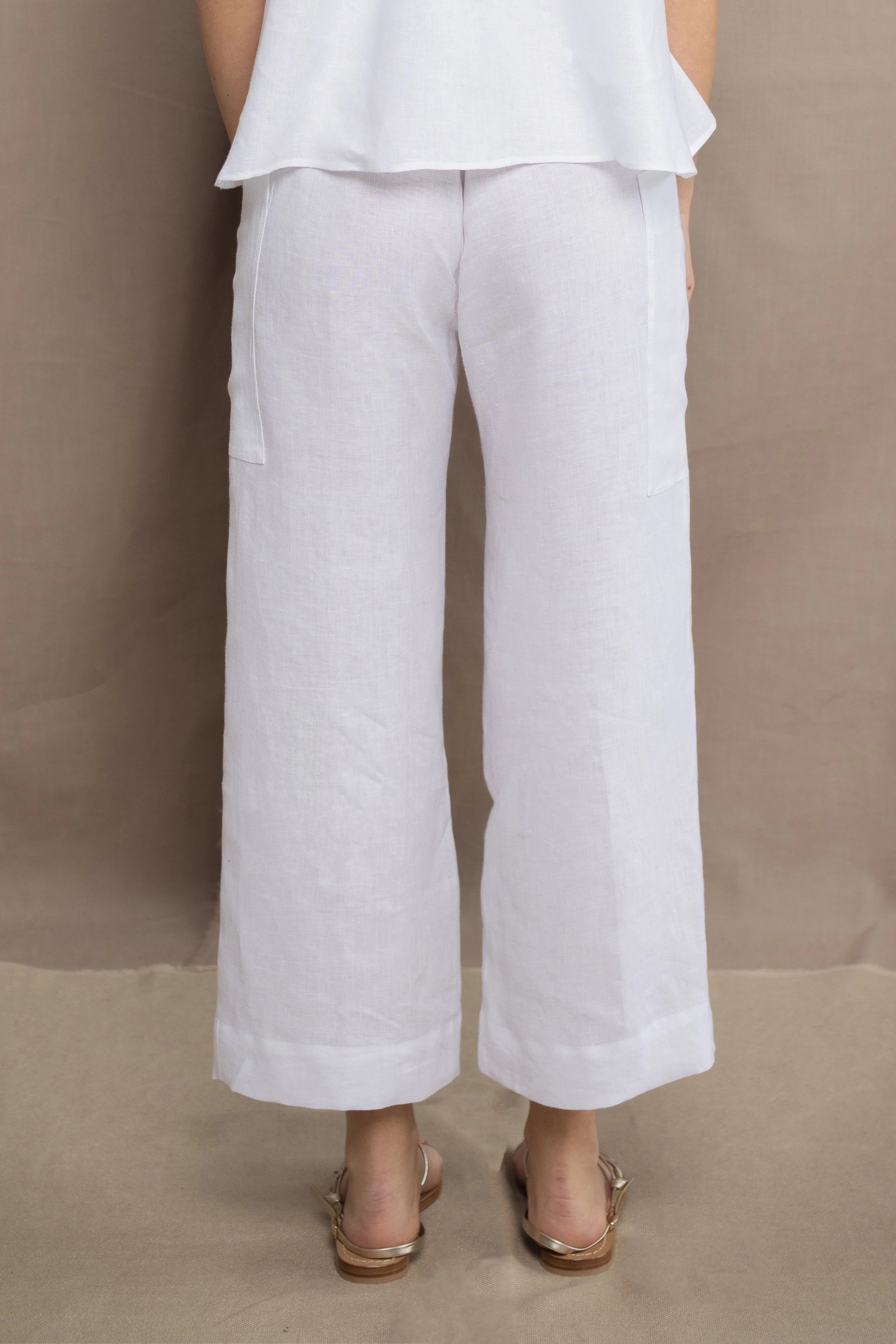 a woman wears a pair of pure Irish linen Cropped trousers in white by Irish brand