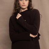 a woman wears a cropped cashmere cardigan in chocolate brown over a matching cashmere tee sweater with a silk skirt in pale yellow