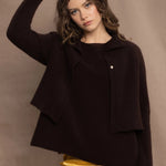 a woman wears a cropped cashmere cardigan in chocolate brown over a matching cashmere tee sweater with a silk skirt in pale yellow