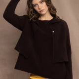 a woman wears a cropped cashmere cardigan in chocolate brown over a matching cashmere tee sweater with a silk skirt in pale yellow