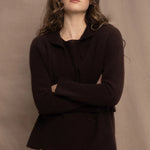a woman wears a cropped cashmere cardigan in chocolate brown over a matching cashmere tee sweater with a silk skirt in pale yellow