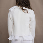 a woman wears a pure 100% cropped cashmere cardigan over an irish linen shirt in white