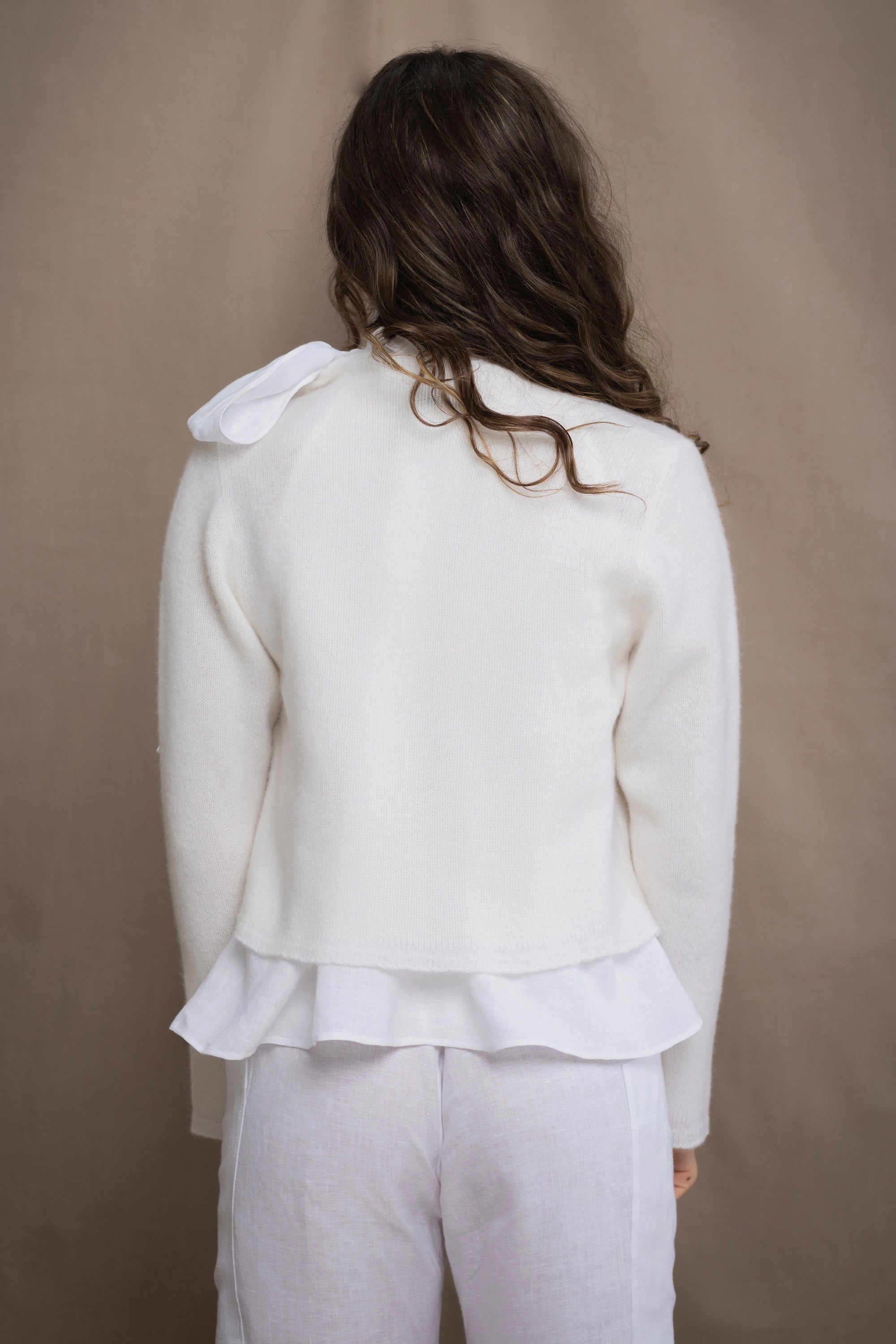 a woman wears a pure 100% cropped cashmere cardigan over an irish linen shirt in white