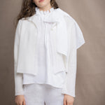 a woman wears a pure 100% cropped cashmere cardigan over an irish linen halter shirt in white