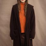 a woman wears a brown luxury cashmere coat in dark brown by Irish brand Madigan