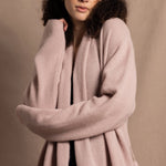 A woman wears a pure 100% cashmere dressing gown or robe in dusty pink
