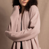 A woman wears a pure 100% cashmere dressing gown or robe in dusty pink