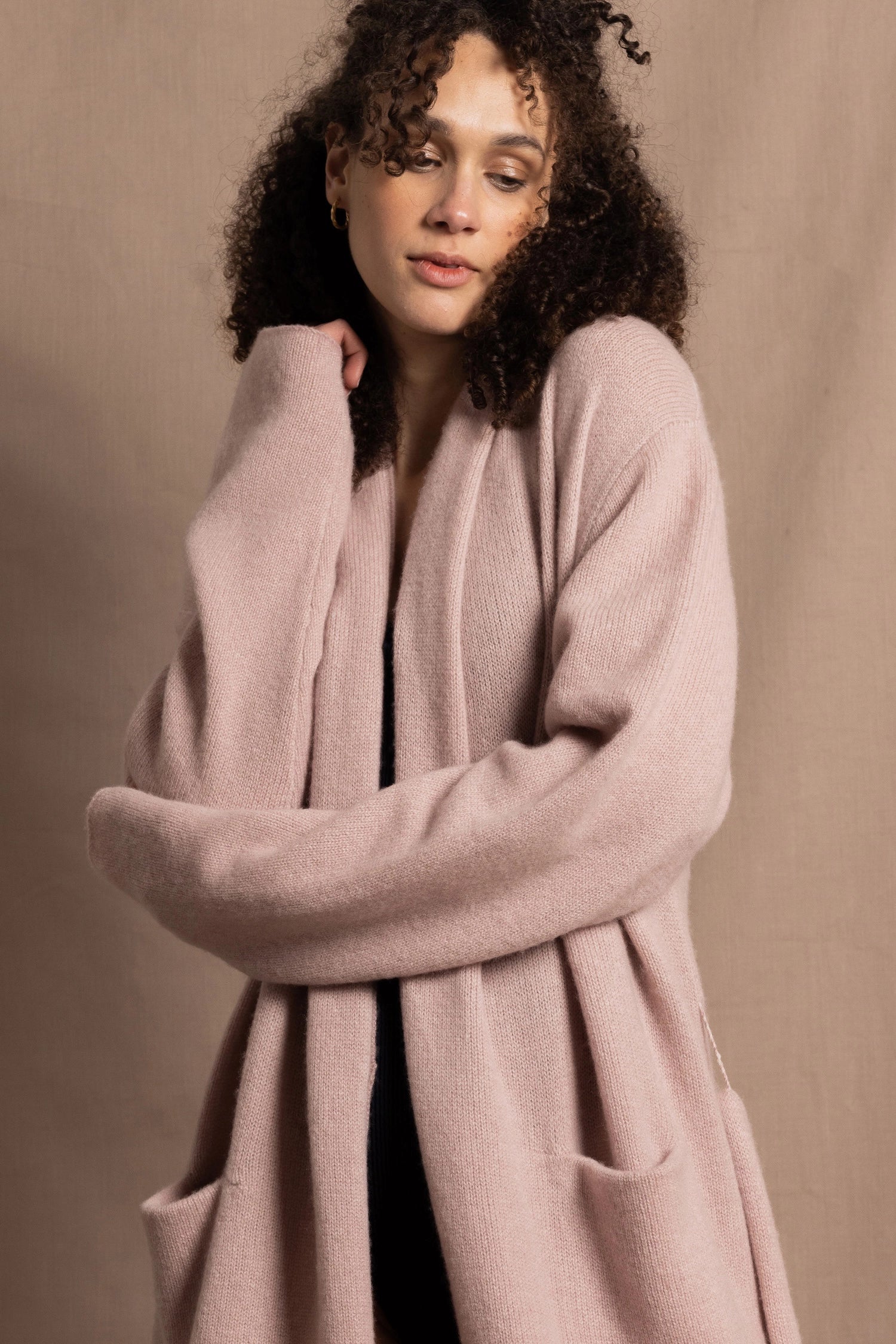 A woman wears a pure 100% cashmere dressing gown or robe in dusty pink