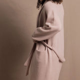 A woman wears a pure 100% cashmere dressing gown or robe in dusty pink