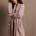 A woman wears a pure 100% cashmere dressing gown or robe in dusty pink