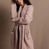 A woman wears a pure 100% cashmere dressing gown or robe in dusty pink
