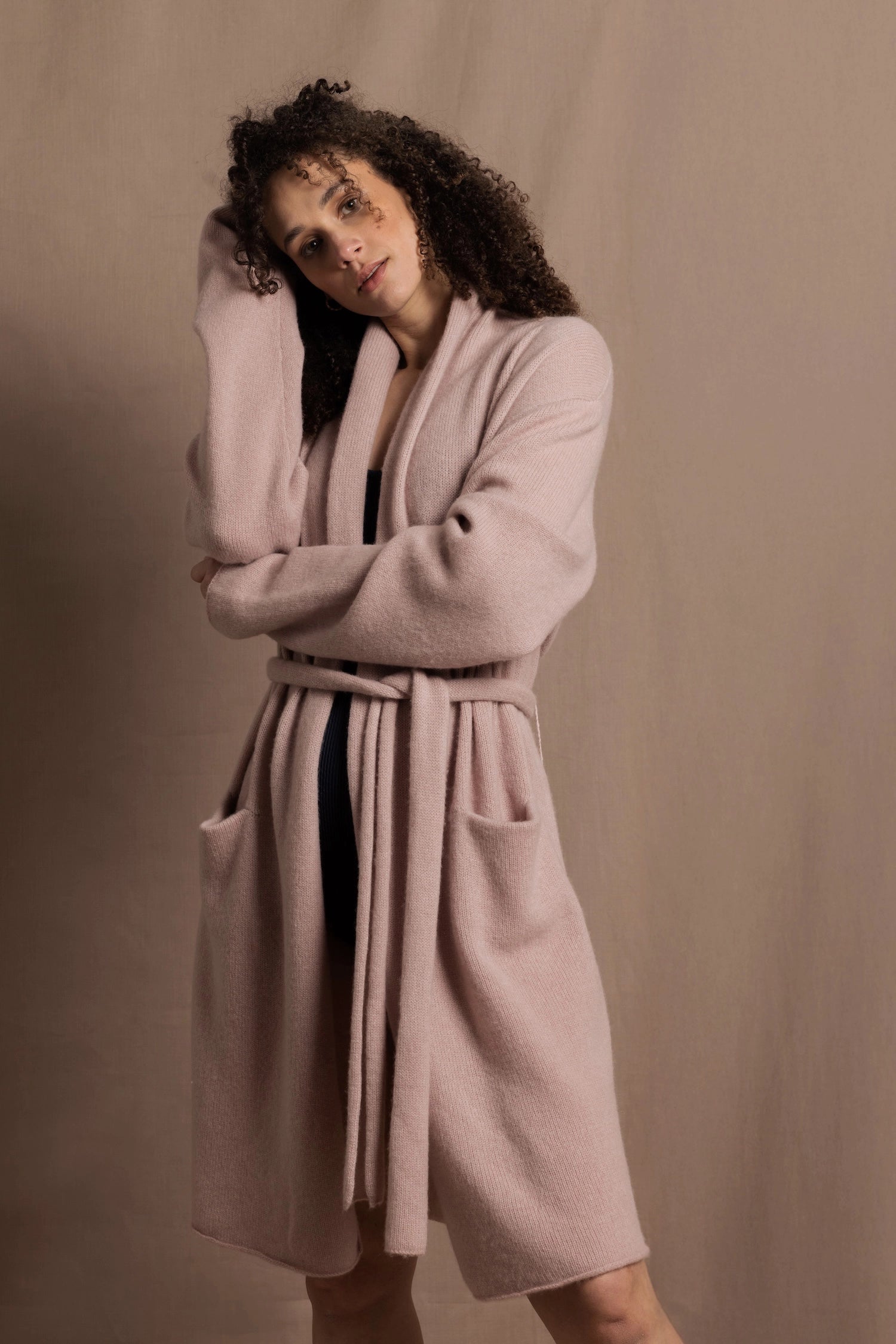 A woman wears a pure 100% cashmere dressing gown or robe in dusty pink