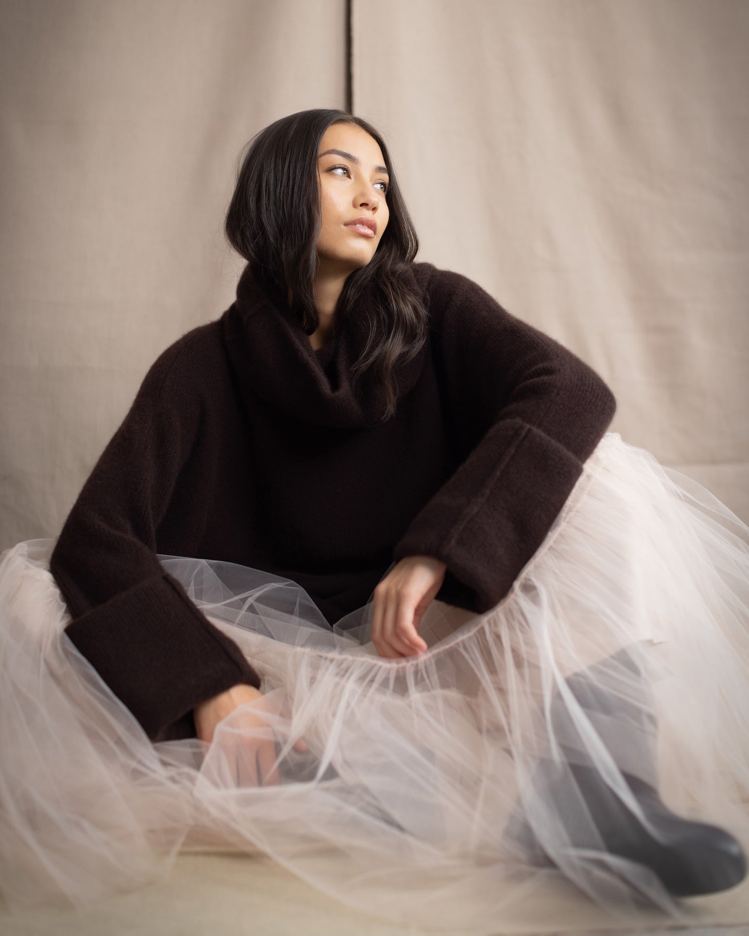 woman wearing a luxury cashmere sweater in dark brown with pale pink tulle ballerina skirt