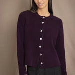 Woman wearing a dark purple cashmere cardigan with mother of pearl buttons