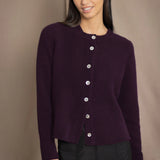 Woman wearing a dark purple cashmere cardigan with mother of pearl buttons