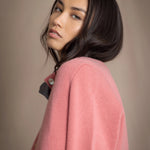 woman wearing a cashmere cardigan  in dusty pink rose with mother of pearl buttons