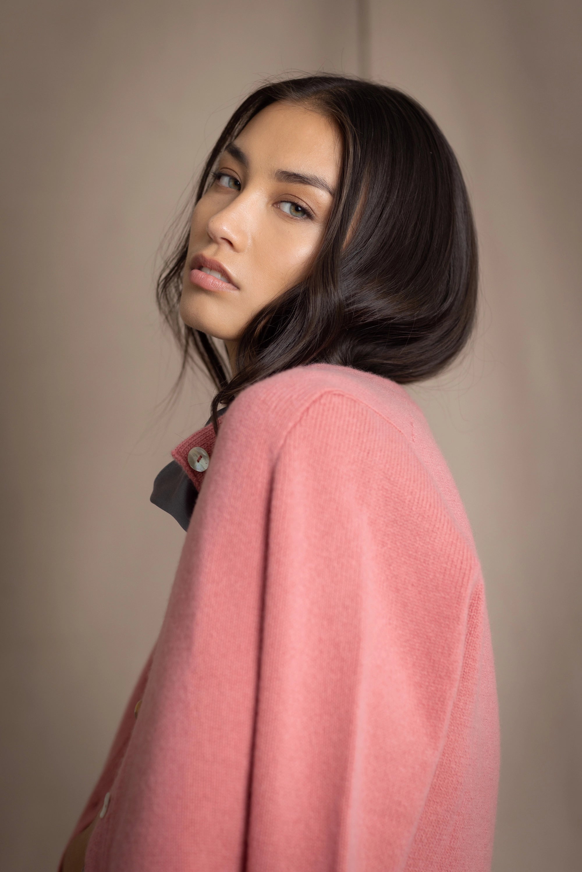 woman wearing a cashmere cardigan  in dusty pink rose with mother of pearl buttons