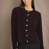 Woman wearing a dark brown cashmere cardigan with mother of pearl buttons