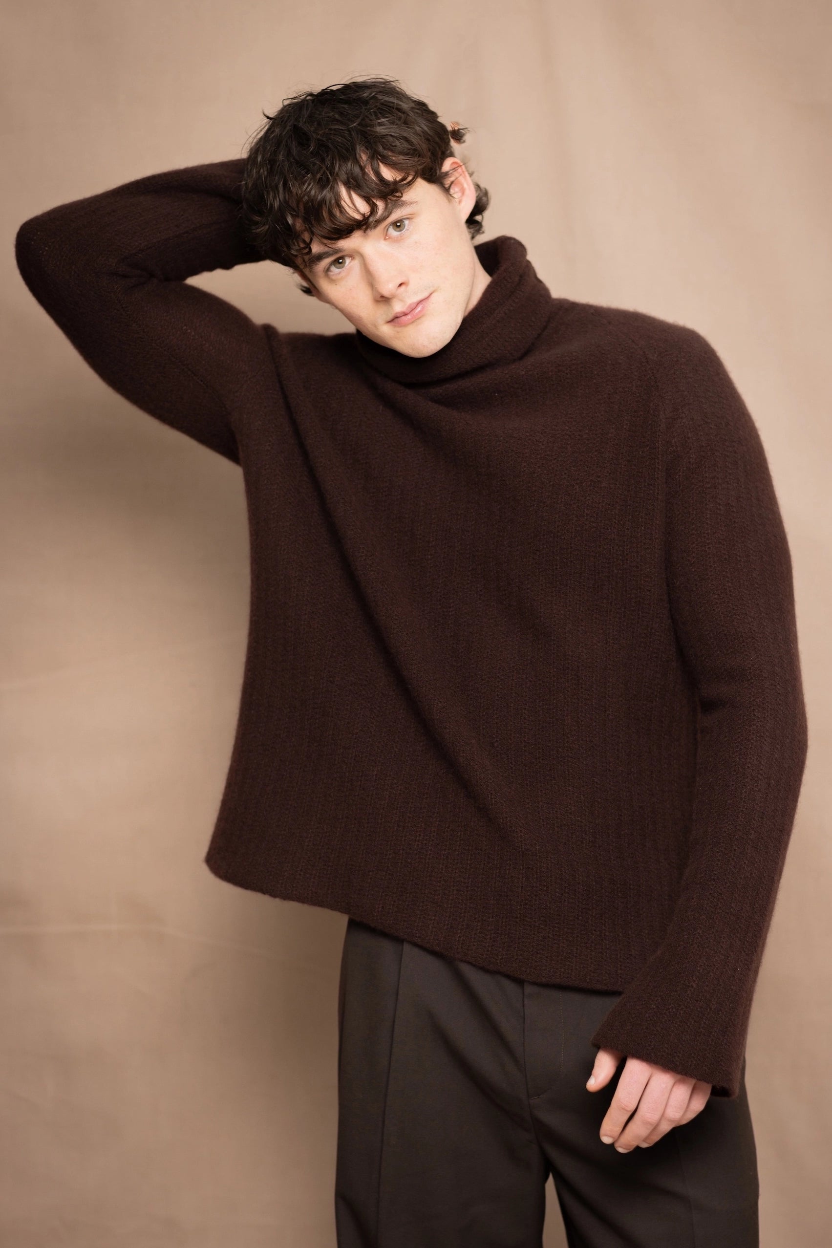 A man wearing a dark brown fisherman cashmere turtleneck sweater from Ireland