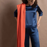 A lady wears a pure silk 3/4 sleeve blouse in teal with matching trousers and large orange cashmere wrap