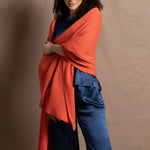 A lady wears a pure silk 3/4 sleeve blouse in teal with matching trousers and large orange cashmere wrap