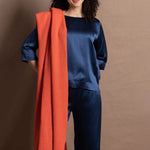 A lady wears a pure silk 3/4 sleeve blouse in teal with matching trousers and large orange cashmere wrap