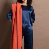 A lady wears a pure silk 3/4 sleeve blouse in teal with matching trousers and large orange cashmere wrap