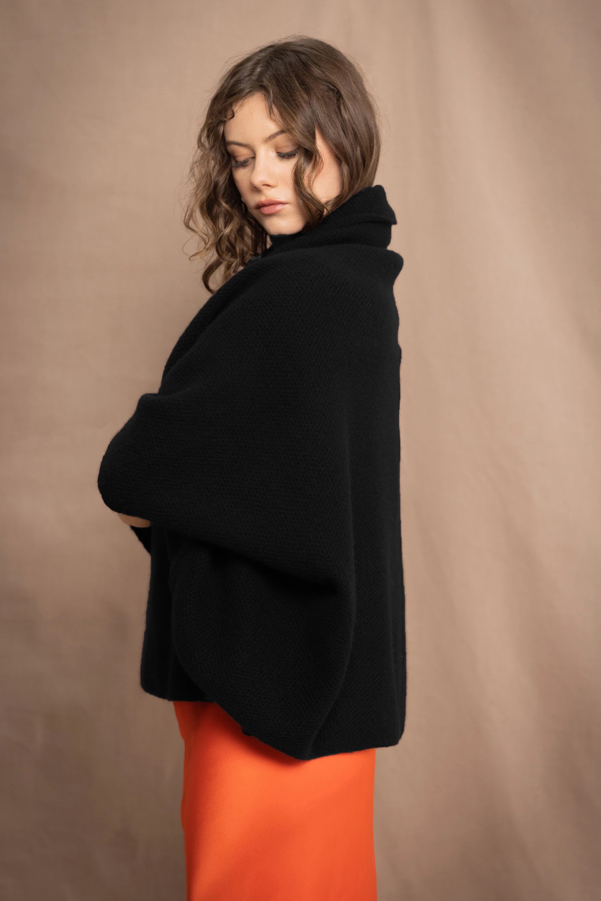 a woman wears a pure 100% cashmere cocoon cardigan in black 