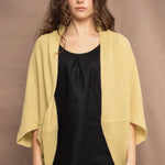 a woman wears a light yellow cashmere cocoon cardigan by Irish brand Madigan Cashmere