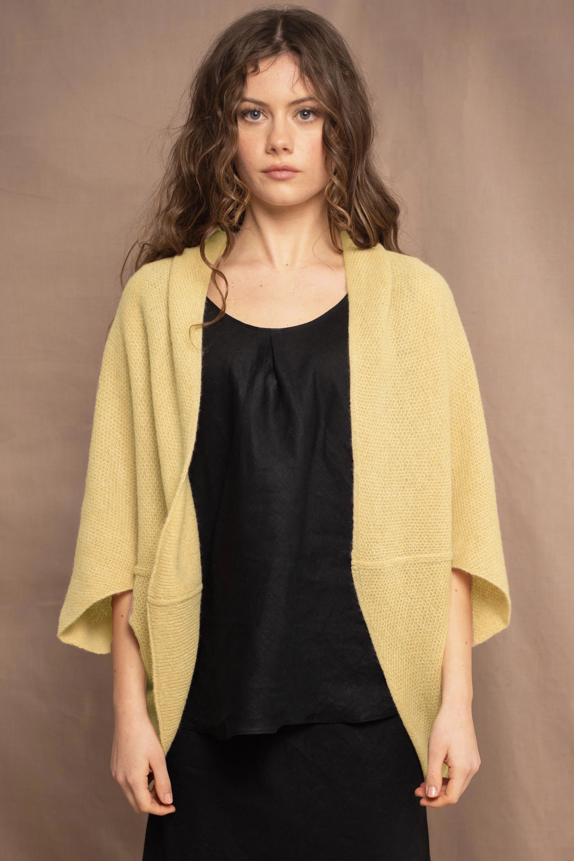 a woman wears a light yellow cashmere cocoon cardigan by Irish brand Madigan Cashmere