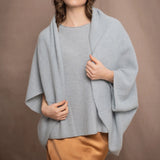 A woman wears a cashmere shawl cardigan in pale blue turquoise colour