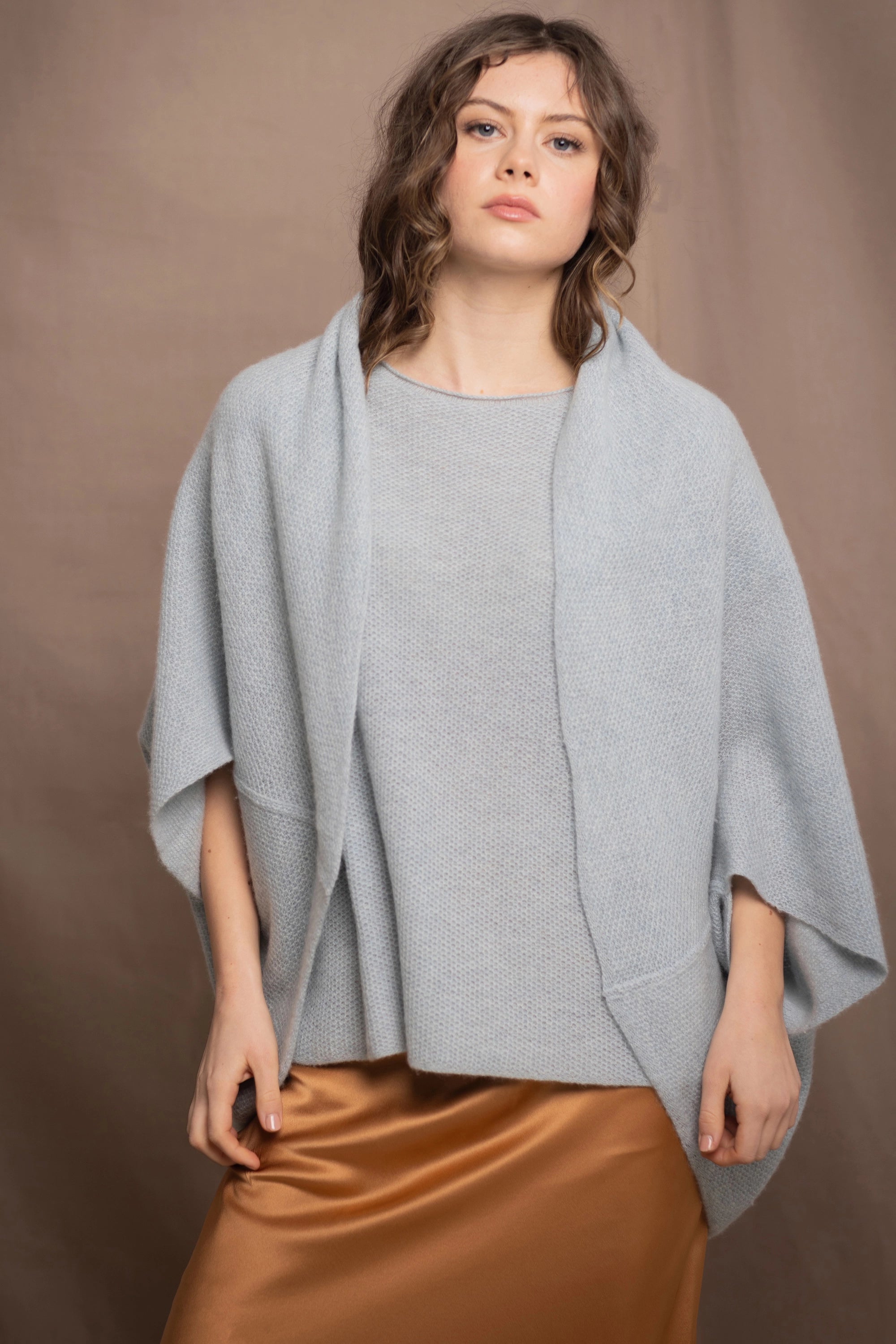 A woman wears a cashmere shawl cardigan in pale blue turquoise colour
