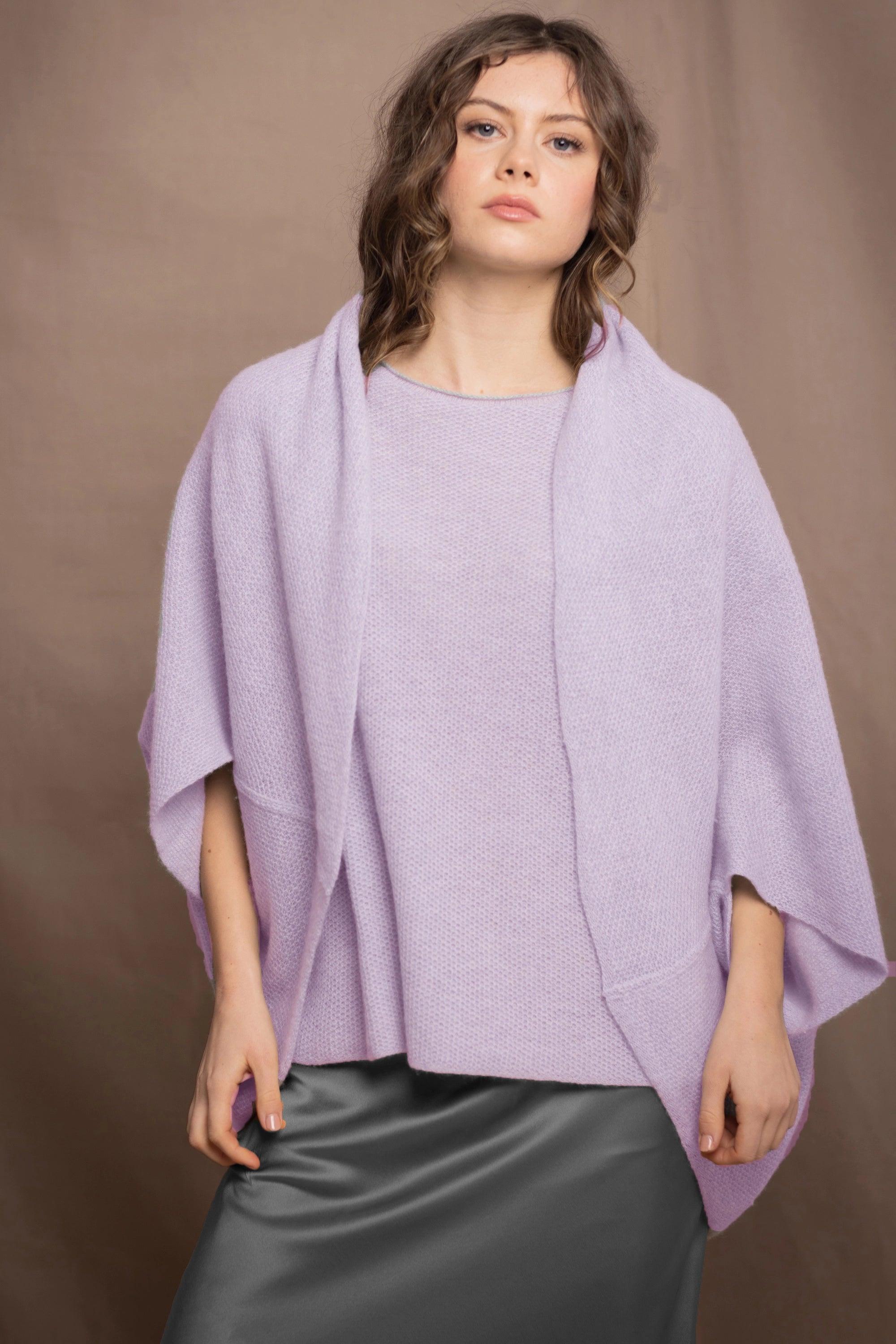 a woman wears a pure 100% cashmere cardigan in a cocoon shape with matching tee sweater in light purple over pewter silk skirt by Irish brand Madigan cashmere