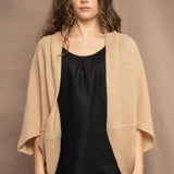 a woman wears a beige cashmere cocoon cardigan with a moss texture by Irish brand Madigan