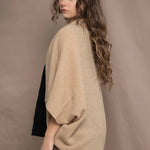 a woman wears a beige cashmere cocoon cardigan with a moss texture by Irish brand Madigan