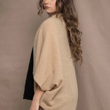 a woman wears a beige cashmere cocoon cardigan with a moss texture by Irish brand Madigan