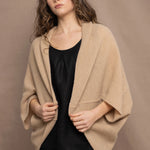 a woman wears a beige cashmere cocoon cardigan with a moss texture by Irish brand Madigan