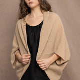 a woman wears a beige cashmere cocoon cardigan with a moss texture by Irish brand Madigan