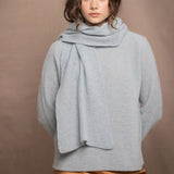 a woman wearing a light blue pure cashmere raglan sleeve sweater jumper and matching cashmere scarf over silk skirt in bronze