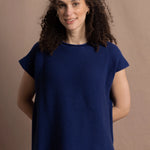 A lady wears a pure 100% cashmere tee sweater jumper in blue over bright pink silk trousers