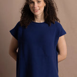 A lady wears a pure 100% cashmere tee sweater jumper in blue over bright pink silk trousers
