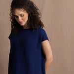 A lady wears a pure 100% cashmere tee sweater jumper in blue over bright pink silk trousers